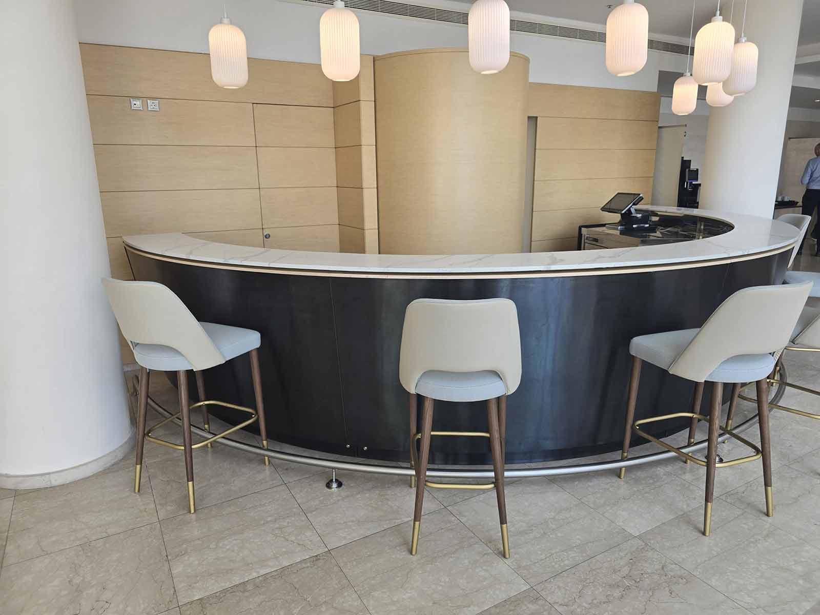 Plain curved hotel bar with marble top before custom branding, during site survey